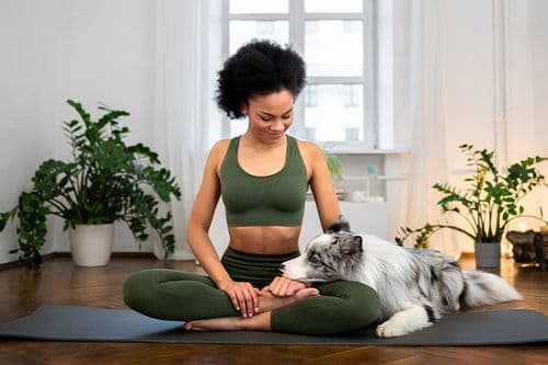A person doing yoga beside their cat